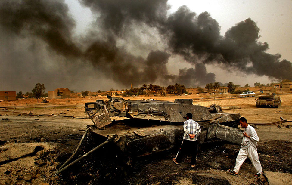 Smoke-filled skies loom over an American tank destroyed during a firefight with Iraqis on the south side of Baghdad, where U.S. forces met heavy resistance en route to the airport on April 6, 2003. Fires were set as a defense tactic.